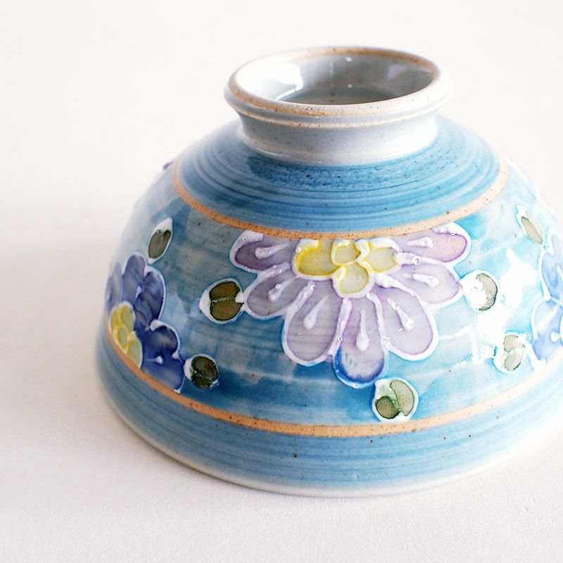 絞り出した釉薬で花柄の輪郭を描いています